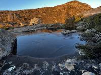 A frozen lake with the Twin Spires peak in the background.