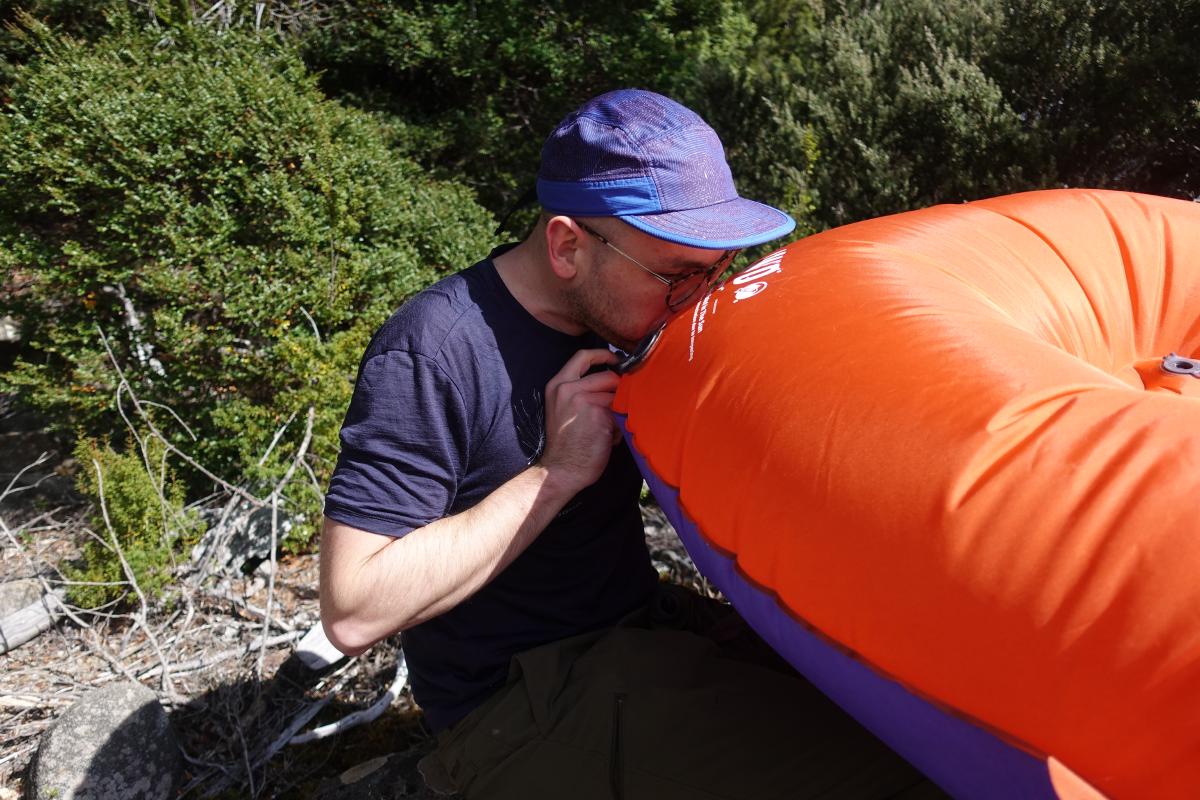 A man blowing up a packraft
