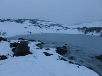 A frozen lake with snow all around it